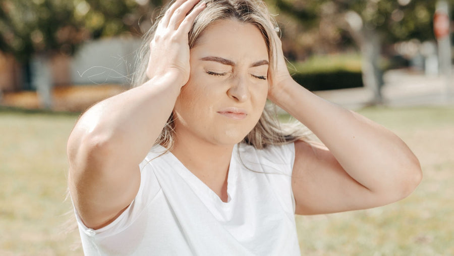 Woman resting in a dim quiet room while recovering from a migraine