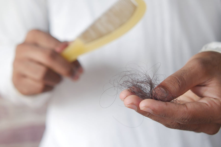 Man checking his hairline in a bathroom mirror while considering hair loss treatment options
